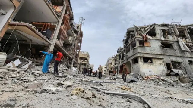 Palestinians inspect the site of an Israeli strike on a house, amid the ongoing conflict between Israel and the Palestinian Islamist group Hamas, in Beit Lahia, in the northern Gaza Strip, May 20