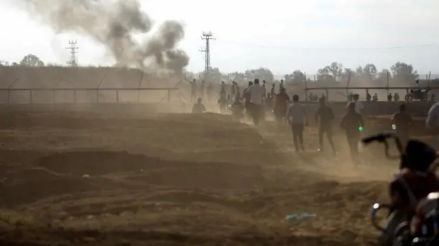 Palestinians break into the Israeli side of the Israel-Gaza border fence after Palestinian gunmen infiltrated southern Israel on 7 October