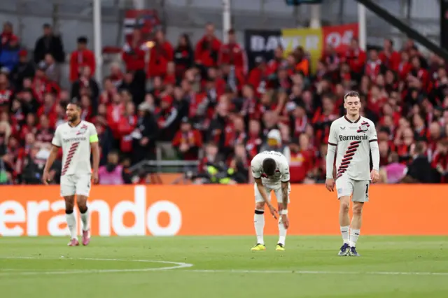 Leverkusen players stand stunned after the second Atalanta goal