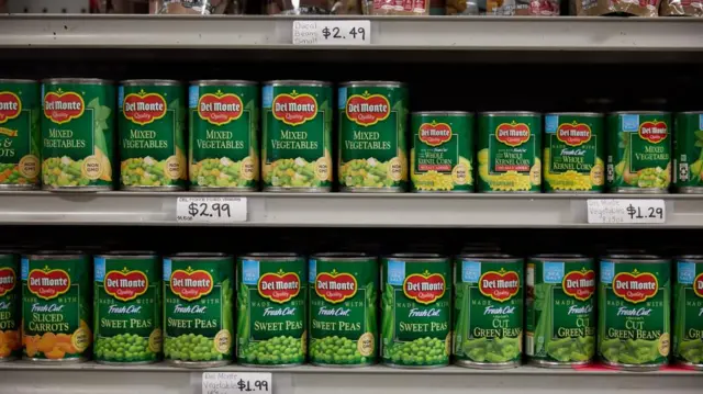 Food cans are seen on the shelves at grocery store.