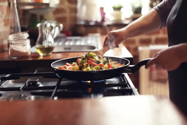 Person cooking on gas hob