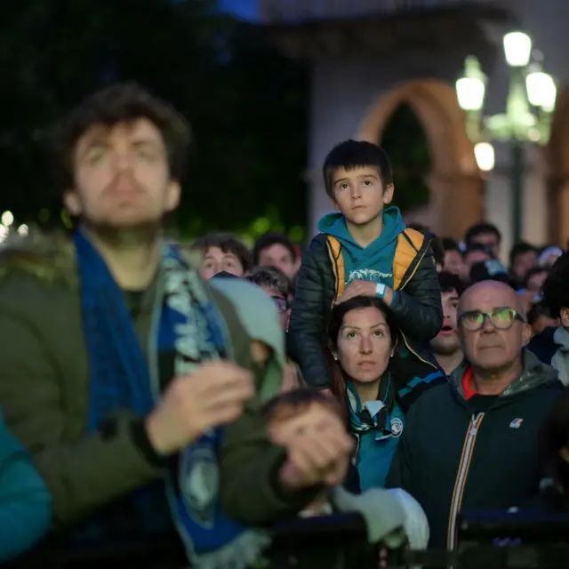 A young Atalanta fan watches from his mother's shoulders