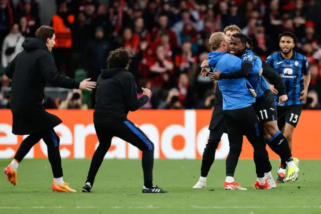 Coaches run onto the pitch to celebrate with Lookman