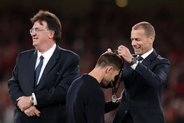 Alonso receives his runners up medal from the Uefa president