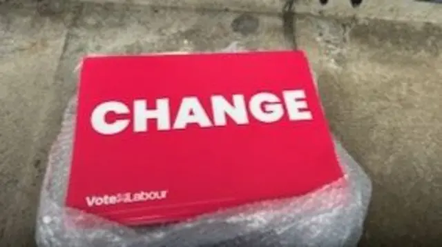 A change placard in bright red is seen on the ground.