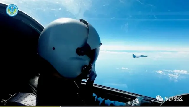 An Air Force pilot navigates an aircraft next to a fighter jet under the Eastern Theatre Command of China's People's Liberation Army (PLA) during military exercises in the waters and airspace around Taiwan, at an undisclosed location August 9, 2022 in this handout image released on August 10, 2022.