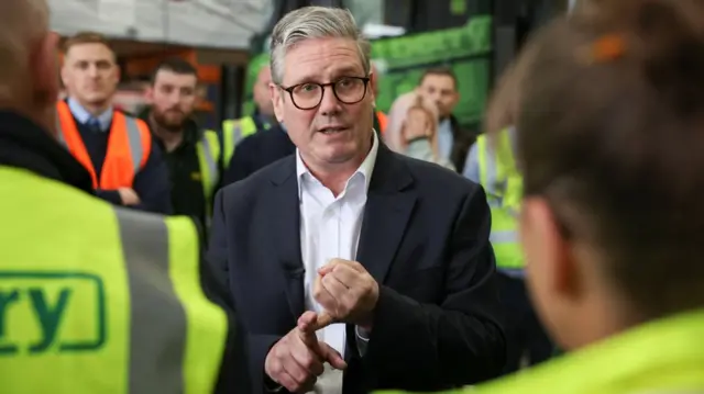 British Labour Party leader Keir Starmer speaks with staff, during a visit to C&W Berry builders merchants, in Leyland, Lancashire