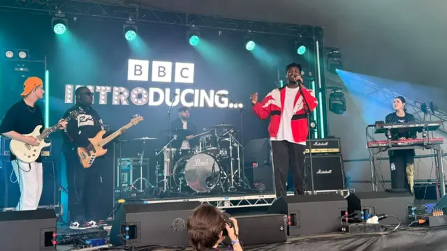 Victor Ray performing with a band on the BBC introducing stage