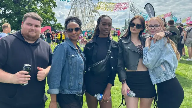 Ripley, Freya, Iris, Charlene, Ryan stood in front of a ferris wheel on a field at Big Weekend