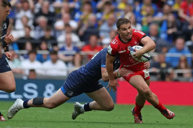 Antoine Dupont is tackled by Robbie Henshaw