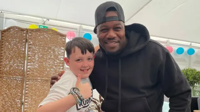 Josh Lynch, 10, gives a thumbs up as he poses for a photo with Locksmith from Rudimental.