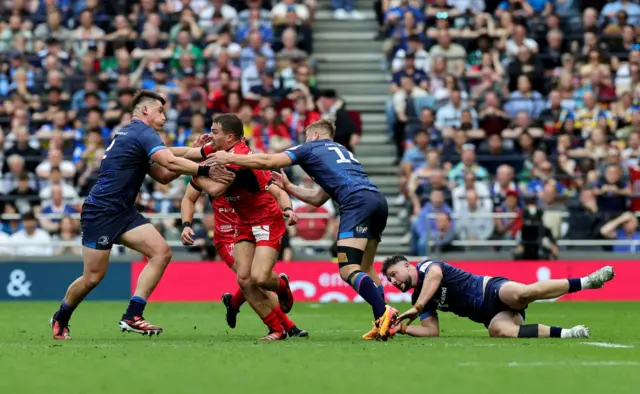 Antoine Dupont is tackled by Dan Sheehan and Jamie Osborne