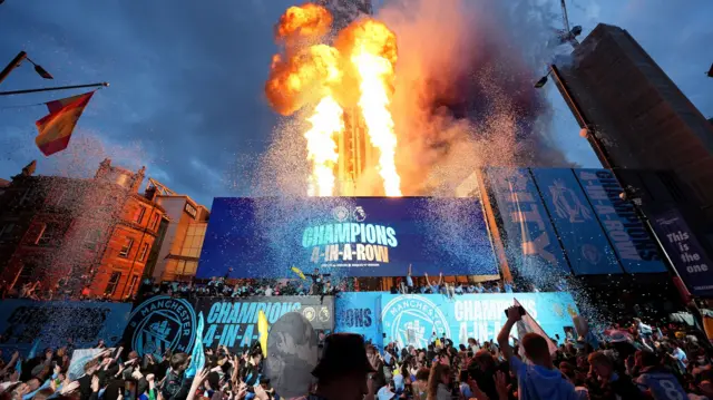 Pyrotechnics as Manchester City players, staff and fans celebrate during a trophy parade in Manchester