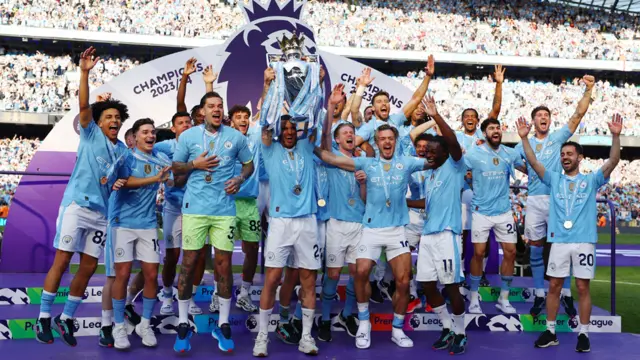 Manchester City's Kyle Walker and teammates celebrate with the trophy after winning the Premier League