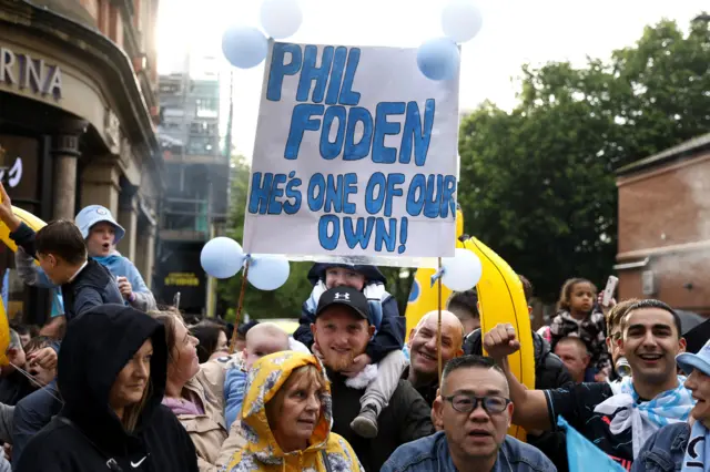 fans with "Phil Foden - He's one of our own" placard