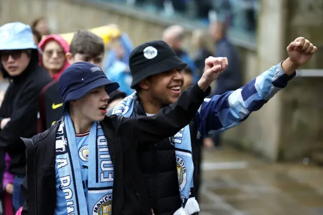 Two boys raise their fists in song