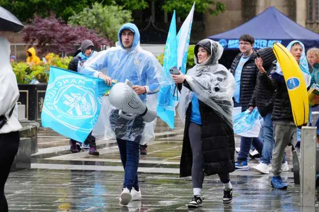 Manchester City fans wait in the rain i