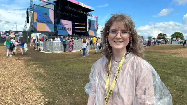 Young woman at Big Weekend in a rain poncho