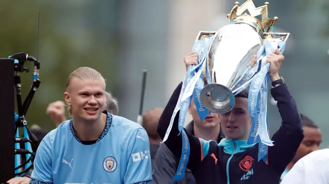 phil foden holds cup with Erling Haaland