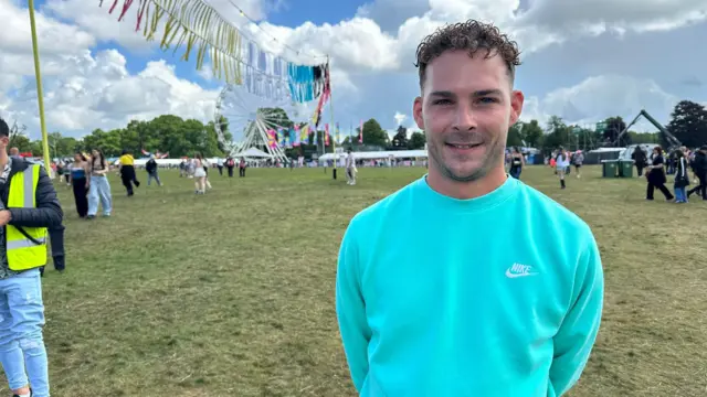 Young man at Big Weekend in a turquoise sweatshirt