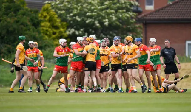 Carlow players and Antrim players tussle at the end of the first half