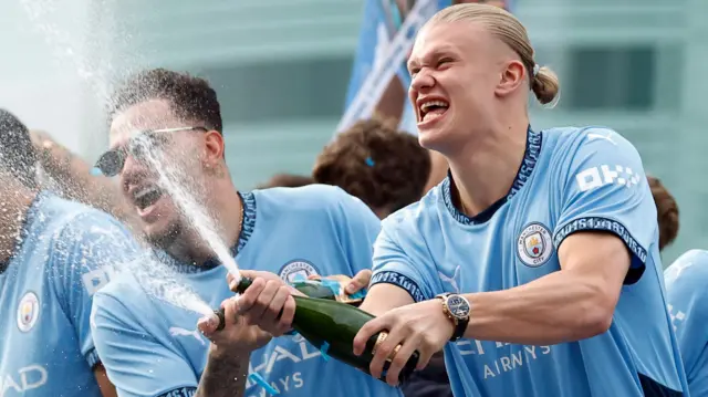 Manchester City's Erling Braut Haaland and Ederson celebrate on the bus