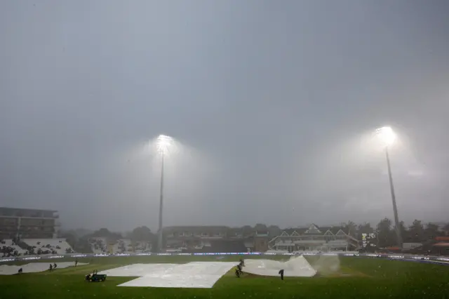 General view of covers on the field as rain stops play