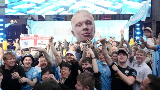 Fans holding a giant cut-out of Erling Haaland's head