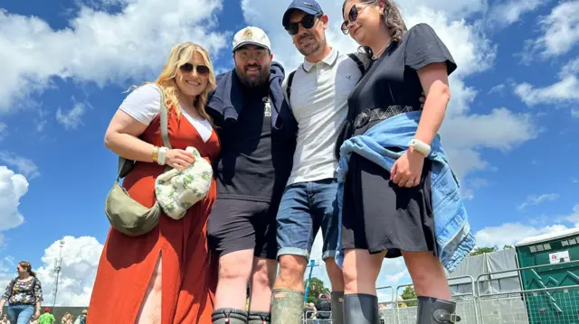 Two men and two women wearing welly boots.