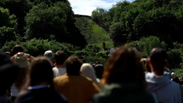 People watch the cheese rolling races in Gloucestershire from a long distance