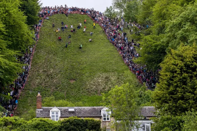 Contestants go down Cooper's Hill in the annual Gloucestershire cheese rolling race, watched by thousands of people on the sidelines