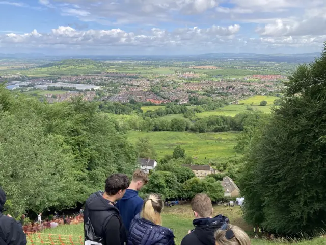 Four people standing at the top of Cooper's Hill