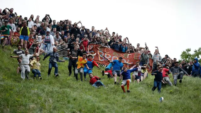 Cheese rolling competitors begin a race down Cooper's Hill in Gloucestershire