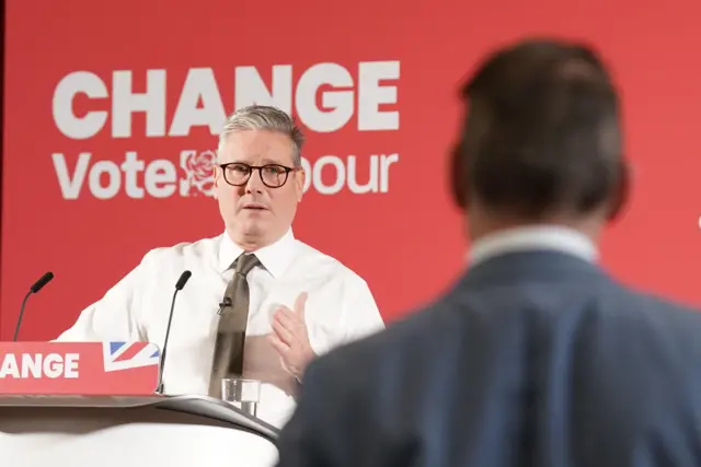 Sir Keir Starmer is at a podium and takes a question from a journalist