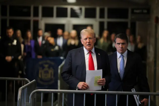 Donald Trump speaking outside court with his lawyer standing next to him.