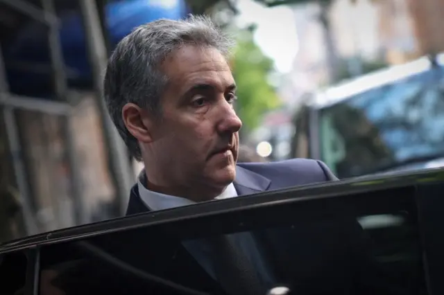 Michael Cohen opens a car door on a New York street