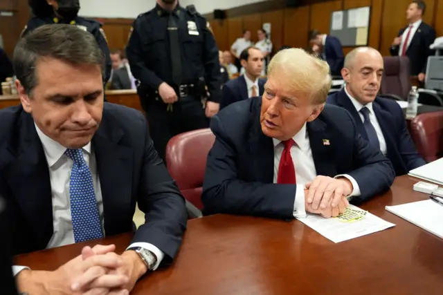 Donald Trump sitting at the defence table in court.