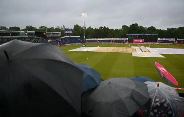 Fans huddled under umbrellas at a rainy Cardiff