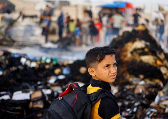 A Palestinian boy stands at the site of Sunday's strike on Rafah