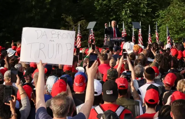 A person holds up a sign as former U.S. President and Republican presidential candidate Donald Trump speaks during a campaign rally