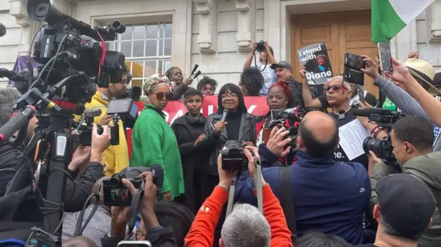 Diane Abbott in front of Hackney Town hall, she is surrounded by supporters and journalists