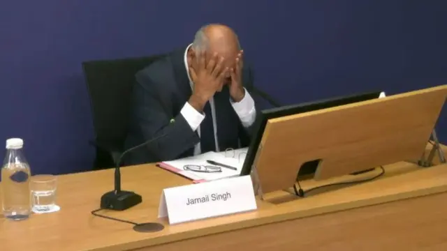 Singh leans his elbows on a desk, his head in his hands