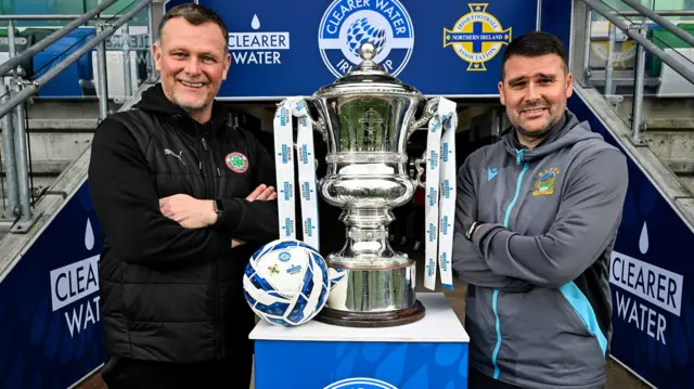 Reds boss Jim Magilton and Linfield manager David Healy with today's prize