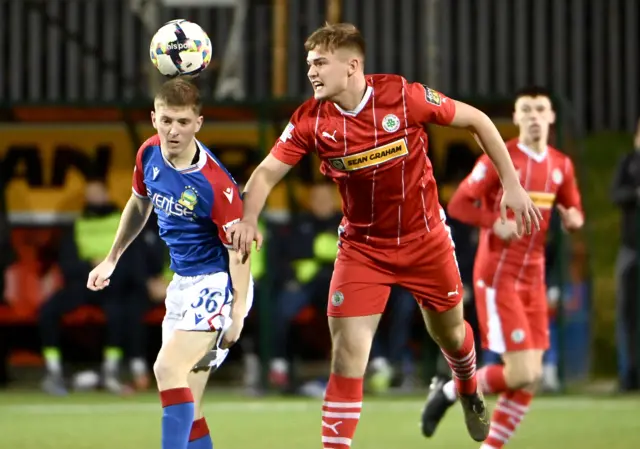 Cliftonville's Odhran Casey beats Linfield's Rhyss Annett to the high ball