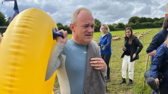 Lib Dem leader Ed Davey carrying a rubber ring