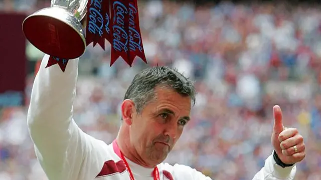 Burnley manager Owen Coyle holding the Championship play-off trophy in 2009