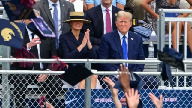 Melania Trump claps her hands while sitting next to Donald Trump at her son, Barron's, graduation cermoney