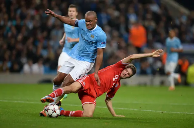 Manchester City's Vincent Kompany challenges Bayern Munich's Thomas Muller