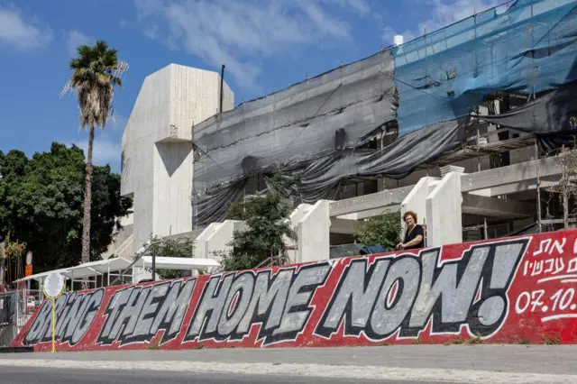 A woman looks on near graffiti for the hostages kidnapped during the deadly October 7 attack by the Palestinian Islamist group Hamas from Gaza, in Tel Aviv, Israel, May 31, 2024.