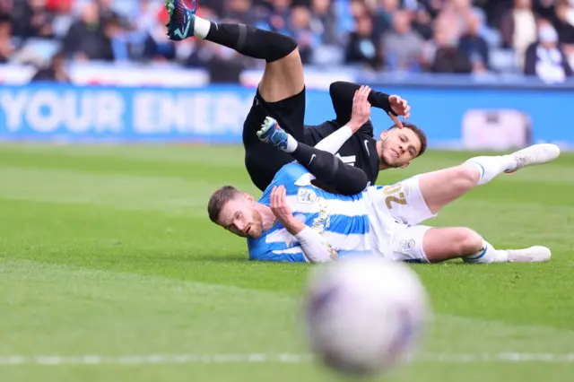 Oliver Turton of Huddersfield Town is tussling with Lee Buchanan of Birmingham City